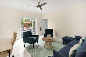 A living room with a ceiling fan, a round coffee table, a sofa, and a chair.