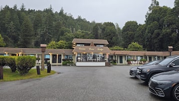 A lodge with a central building labeled "Ocean Cove Lodge" and a parking area with two cars.