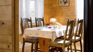 Ein Esszimmer mit Holzboden und einem für vier Personen gedeckten Tisch, umgeben von Stühlen.