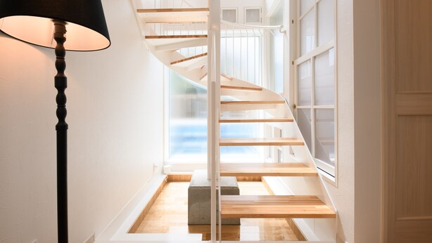 A spiral staircase with wooden steps and white railings, leading to an upper floor. - Wakoso Harmonious Light South (Hakone)