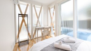 A modern hotel room with a bed, a desk, and a view of the outdoors. - Wakoso Harmonious Light South (Hakone)