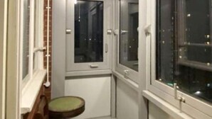 A narrow hallway with a small window, a door, and a toilet. - Room in Apartment - Normanton - Deluxe Double Room (Birmingham)