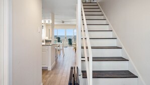 Un interior moderno con una escalera que lleva a un balcón.