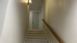 Eine Treppe mit wei ßen Geländern und Holzstufen, die zu einer Tür oben führen.