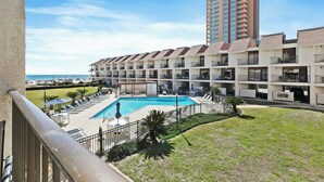 Un hotel con piscina, varios balcones y vista a la playa.