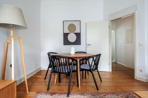Enjoy meals in this stylish dining area with a round table, comfortable chairs, and a beautiful abstract painting.