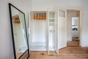 Spacious room with a large mirror and ample wardrobe space.