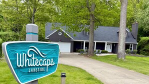 Naamplaatje voor Whitecaps Lakeside, met een huis op de achtergrond.
