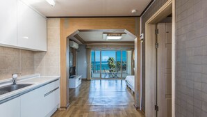 Una cocina moderna con horno integrado, un lavamanos y una zona de comedor con mesa y sillas.