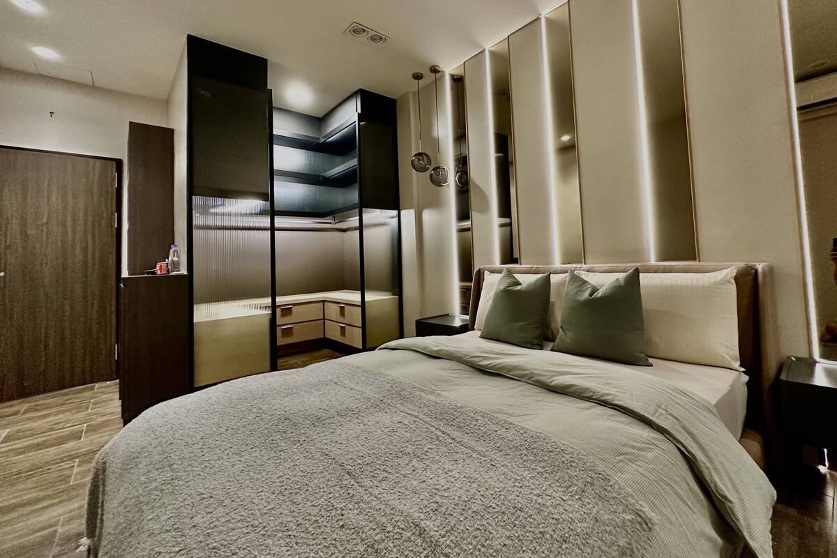 Ein modernes Schlafzimmer mit einem Bett, einem Kleiderschrank und einer integrierten Regallösung.