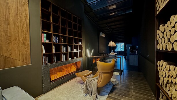 A modern interior with a fireplace, a bookshelf, and a seating area. - HERE Hostel - Pingtung (Pingtung)
