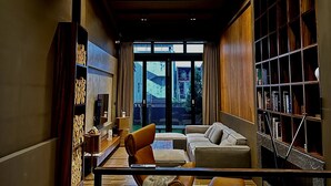 Una sala de estar moderna con un sofá, sillones y una estantería.