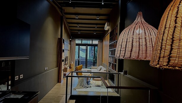 Una habitación de hotel moderna con un ventanal grande, una cama con vistas, un comedor y una cocina.