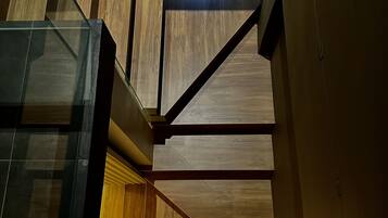 A modern interior with a staircase, wooden panels, and glass elements.
