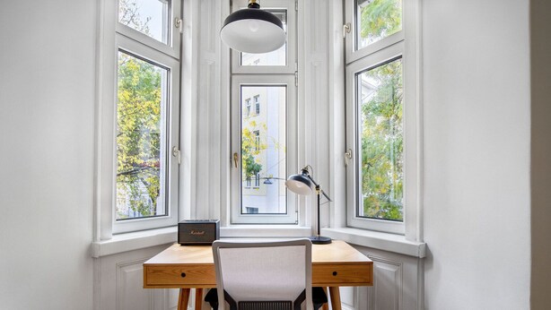 A corner desk with a chair, a lamp, and a Marshall radio.