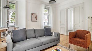 A modern living room with a grey sofa, a red armchair, and a wooden coffee table.