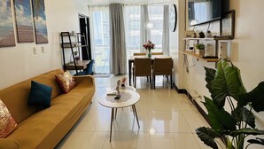 Una sala moderna con sofá, una mesa de centro y una zona de comedor con sillas.