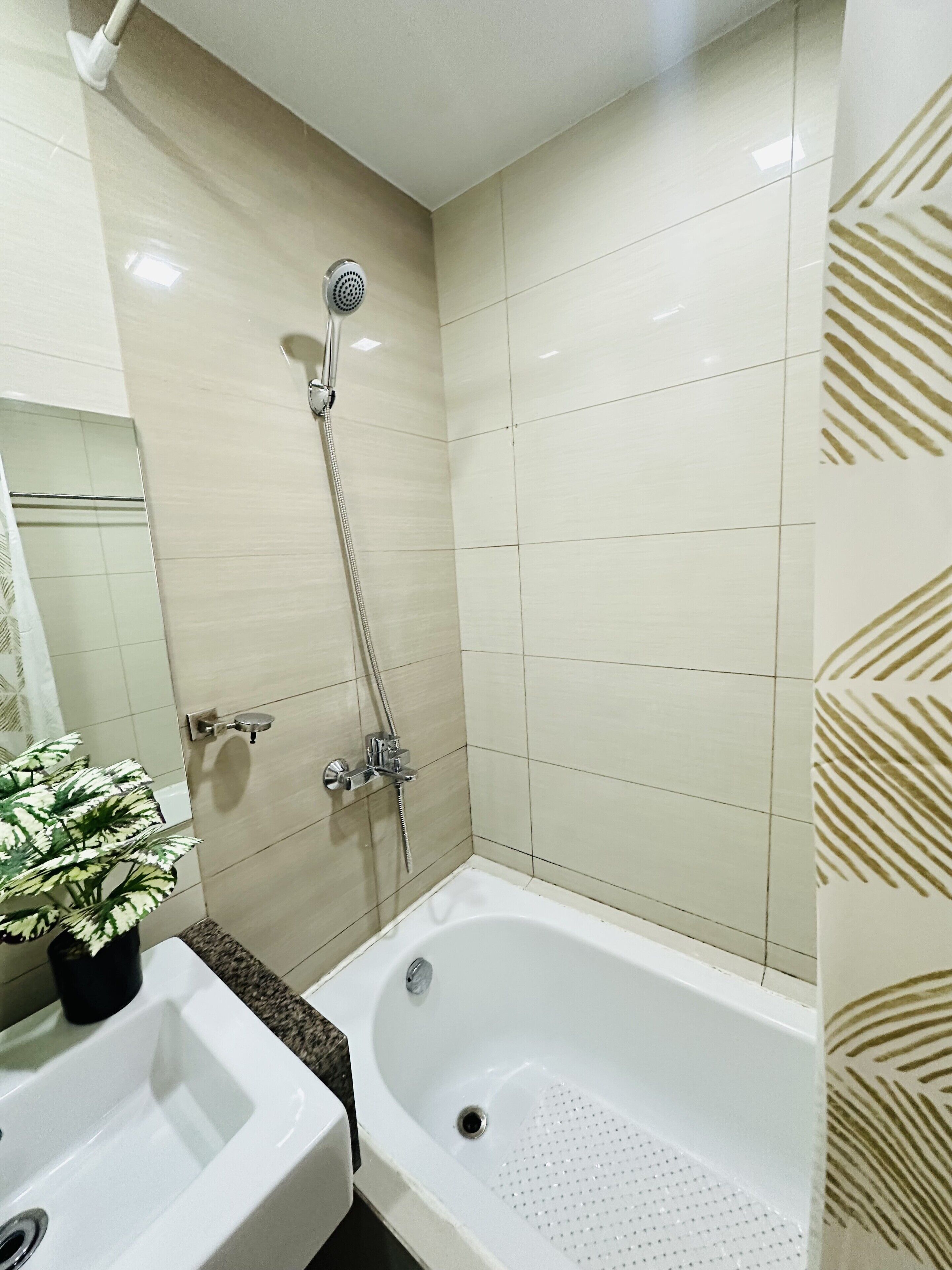 Une salle de bain avec une baignoire, une douche et un lavabo.