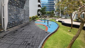 Un edificio moderno con pared de escalar, patio ajardinado y zona de piscina.