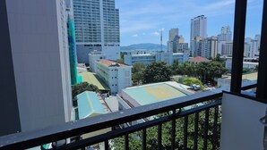 A high-rise building with a view of a cityscape, including other tall buildings and a sports field. - Golden Rain 2 Hotel (Nha Trang)
