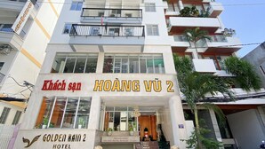 A multi-story hotel with balconies and a sign reading "KHÁCH SÁN HOÀNG VÚ 2". - Golden Rain 2 Hotel (Nha Trang)