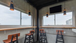 Un interior moderno con cuatro taburetes de madera y dos lámparas colgantes.