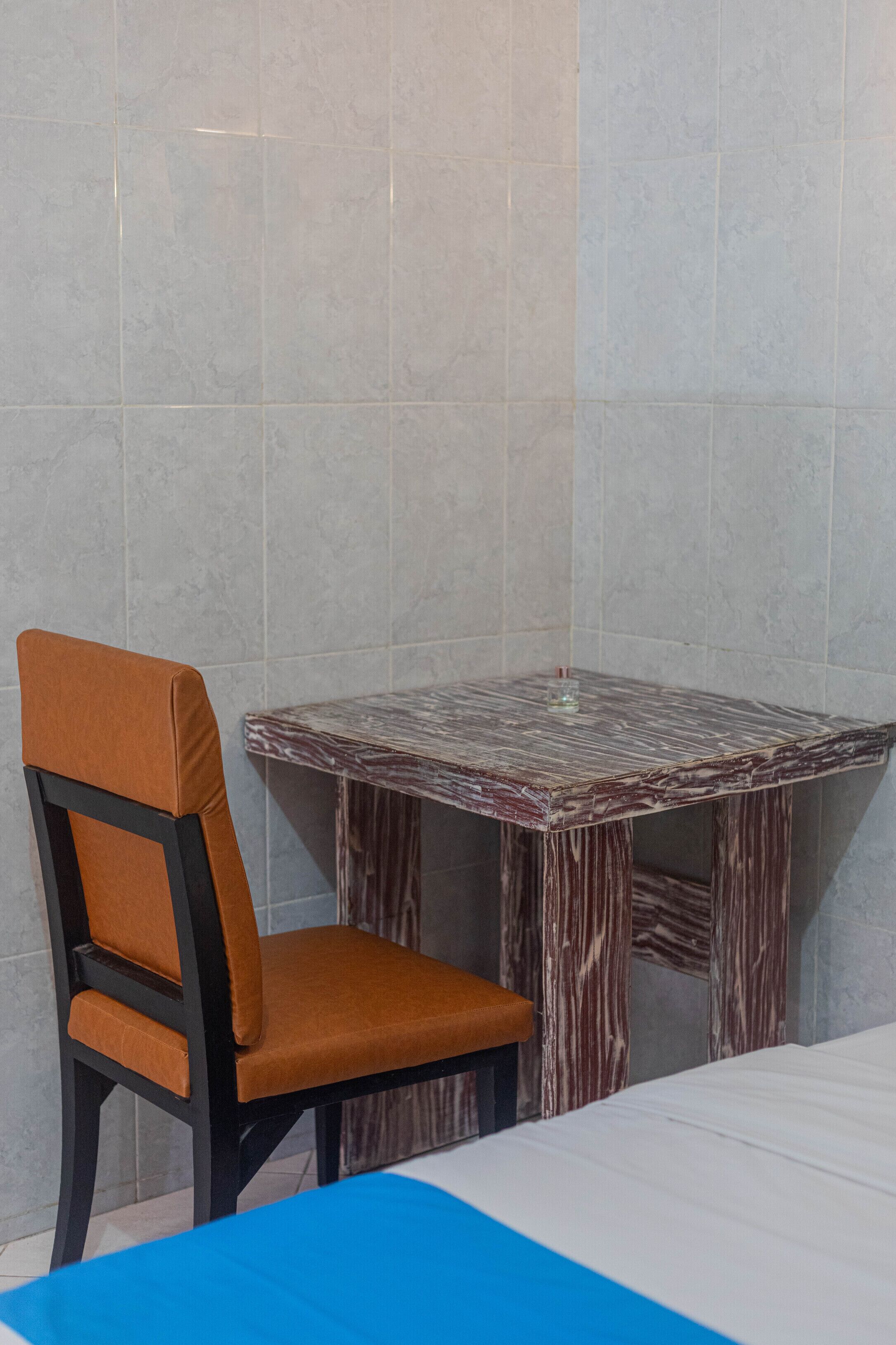 Un coin de pièce avec une chaise, une petite table et un lit.