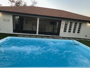 Piscina retangular com um deck revestido em frente.