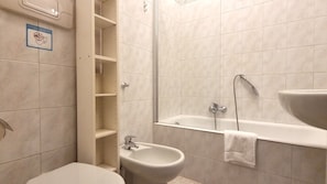 Casa de banho com sanita, bidé e banheira.