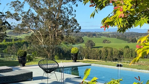 Una piscina con vistas a colinas ondulantes y árboles.