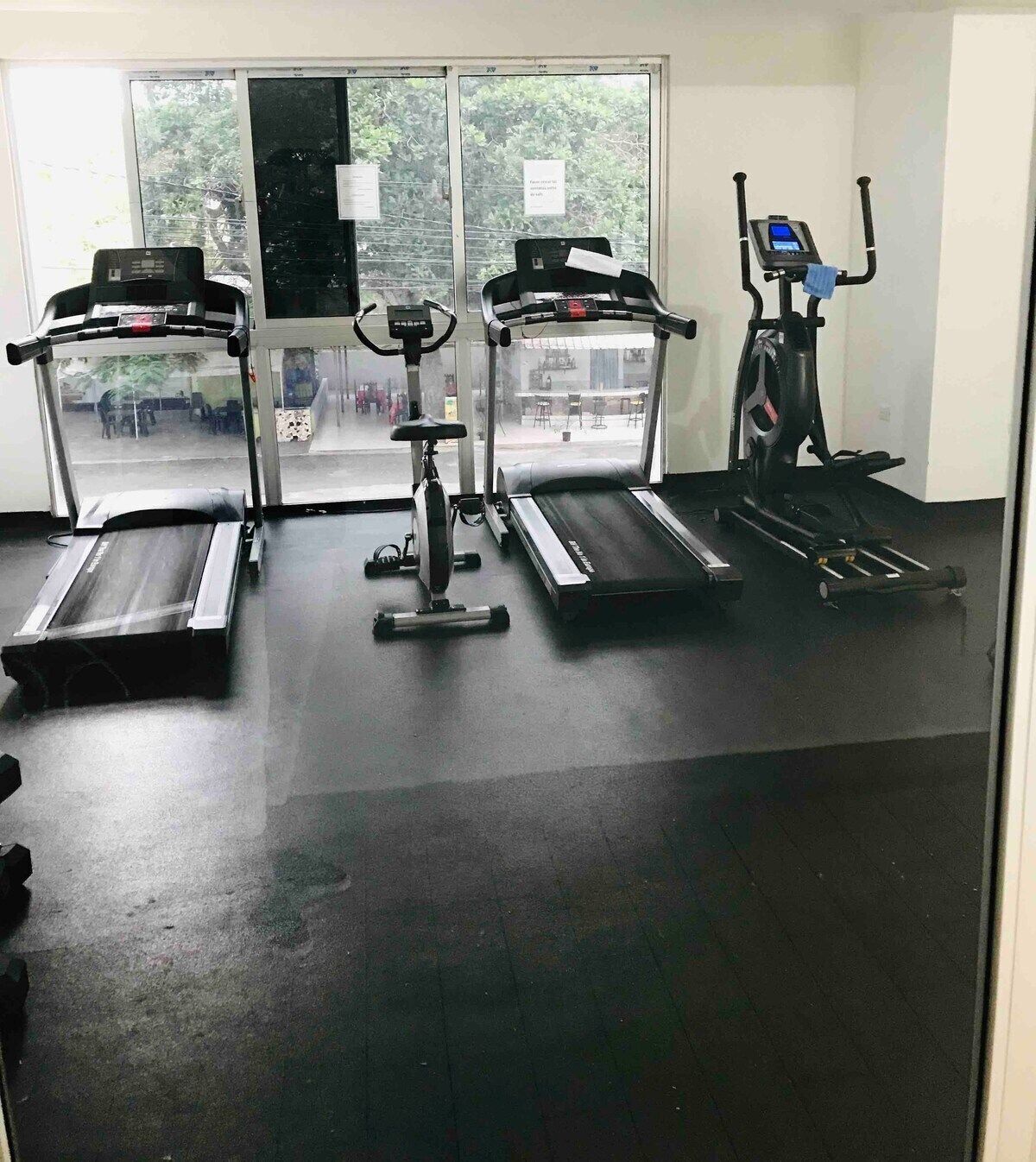 A gym with treadmills, stationary bikes, and an elliptical machine.