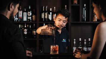 Un bar con un barman sirviendo una bebida en un vaso.