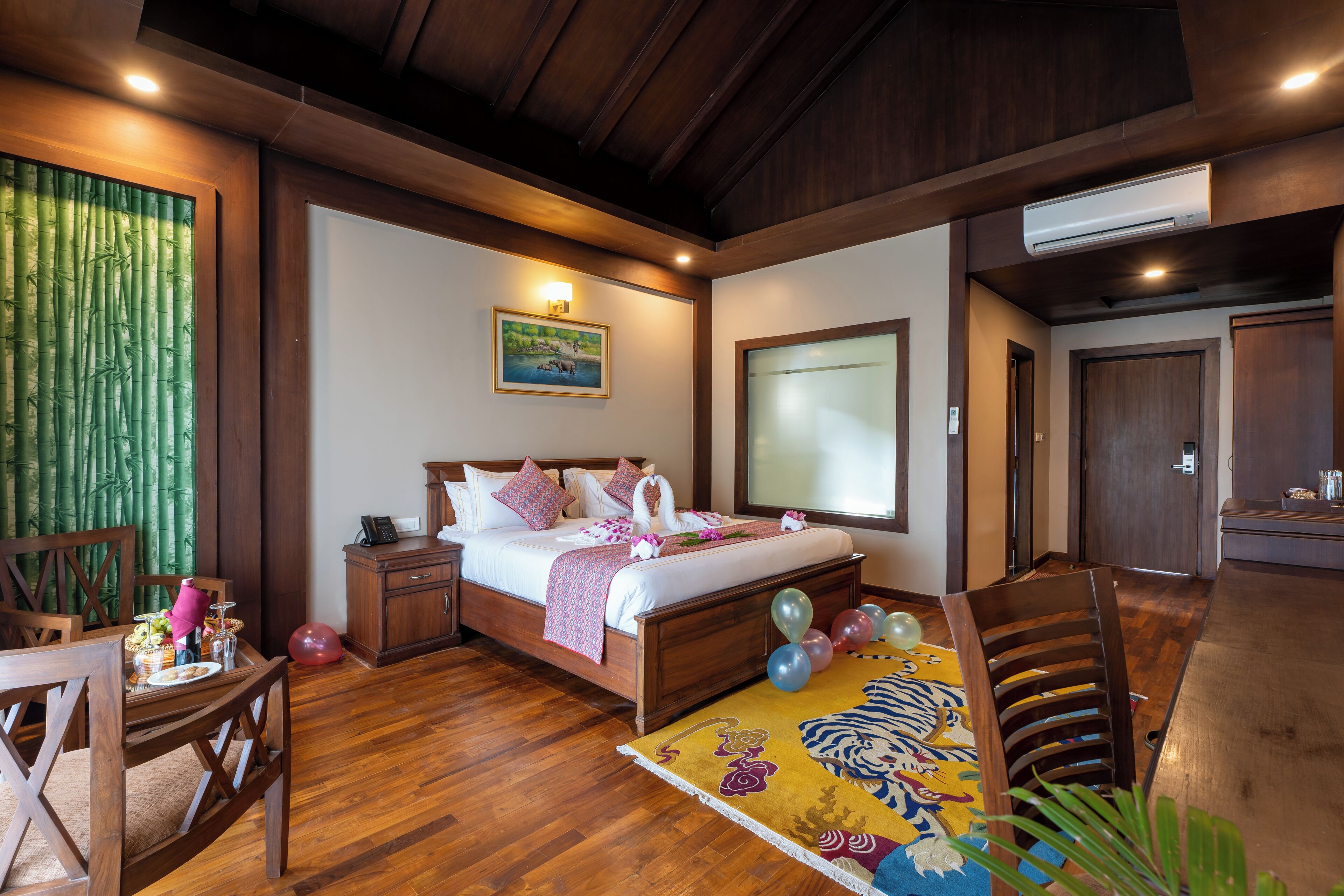 A bedroom with a wooden bed, bedside tables, a desk, and a chair.