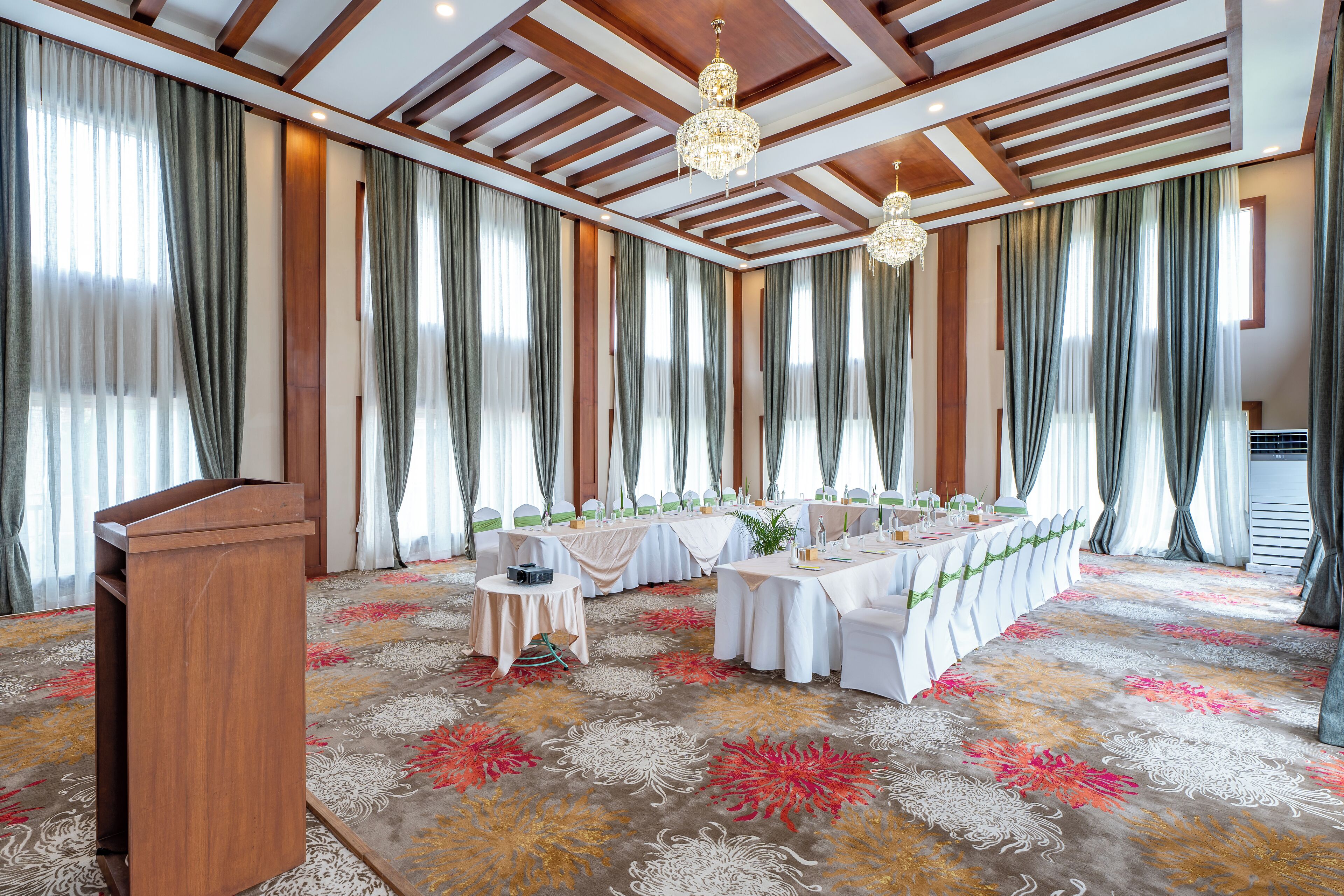 Een feestzaal met lange tafels, een spreekgestoelte en kroonluchters.