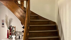 Un escalier en bois, un mur blanc et une table sur laquelle se trouvent divers objets.