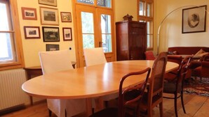 Un coin repas avec une table en bois, quatre chaises, un buffet et des tableaux encadrés accrochés au mur.