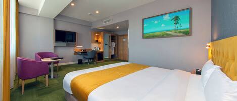 Habitación de hotel con una cama grande, un escritorio, una silla y un televisor.