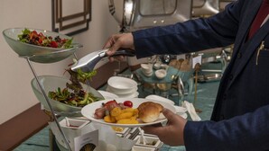 Una mesa de buffet con ensalada, carnes y pan.