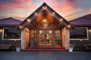 A building with a prominent entrance featuring a wooden facade, large glass doors, and a decorative ceiling. - HM Resort (Dibrugarh)