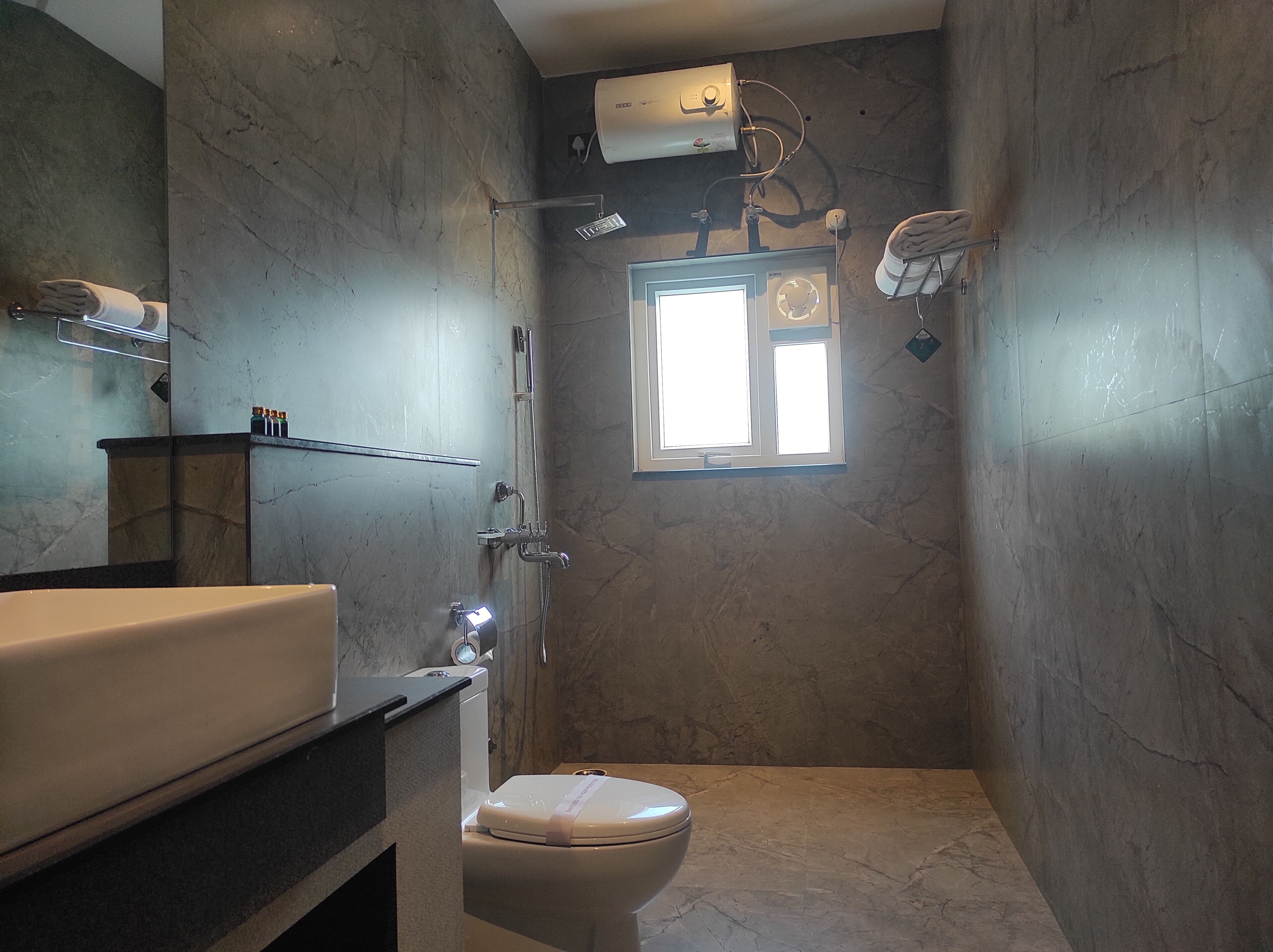 A bathroom with a bathtub, toilet, and a window.