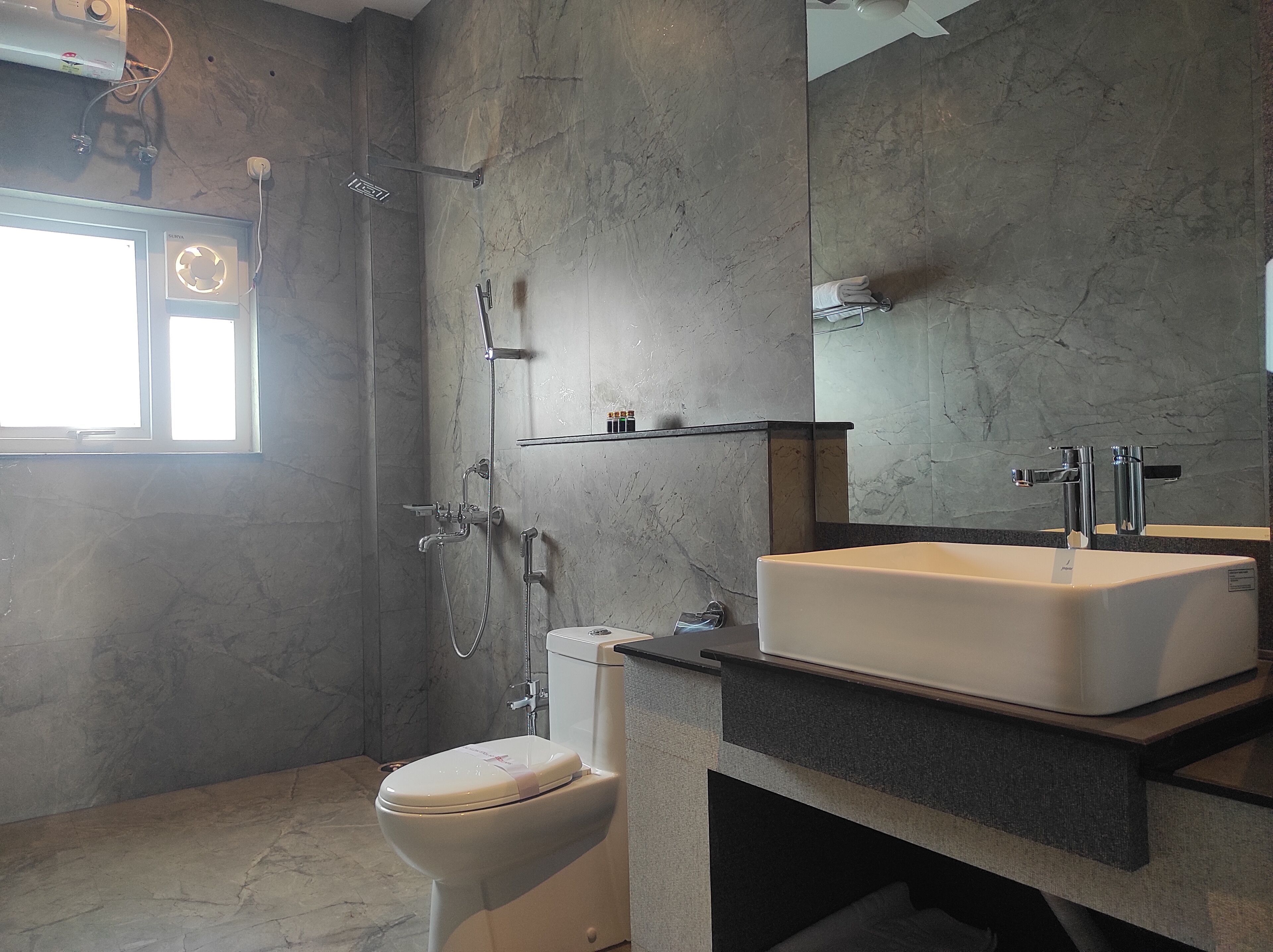 A modern bathroom with a shower, toilet, and sink.