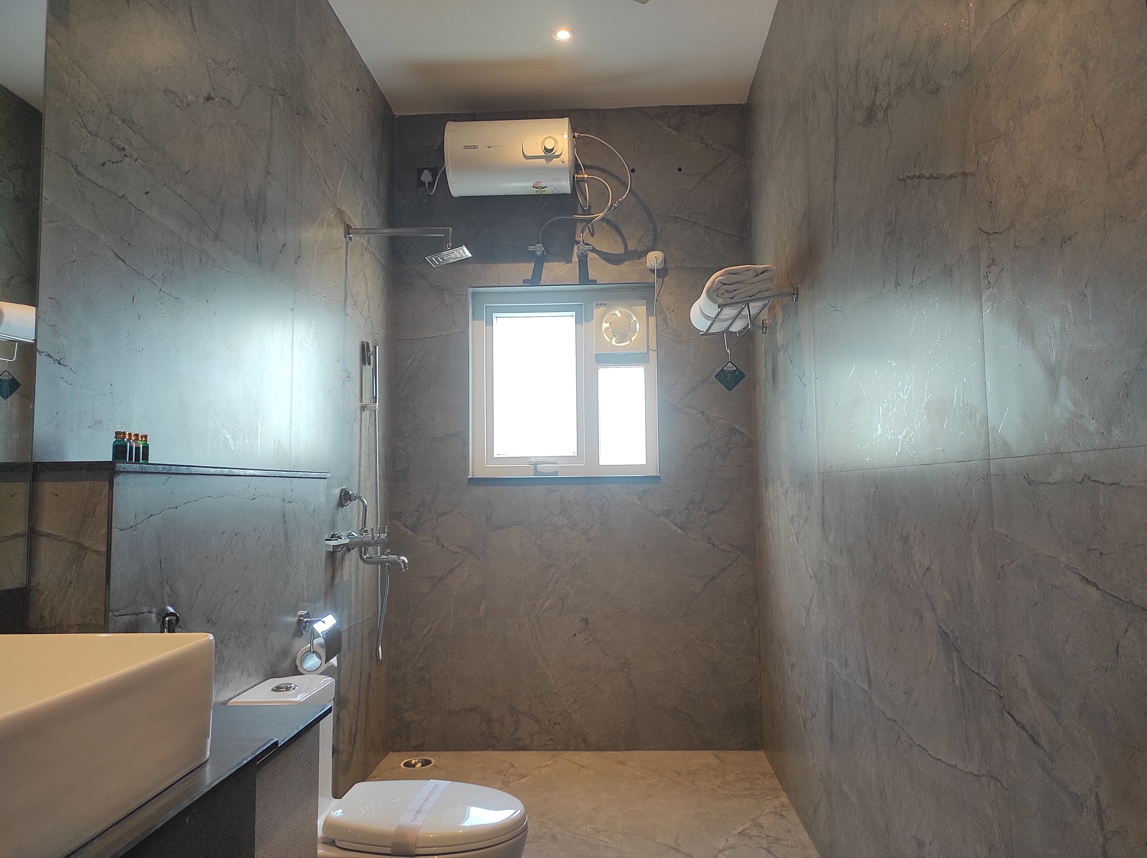 A compact bathroom with a shower, toilet, and sink.
