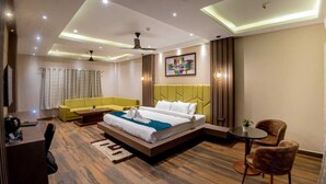 Una habitación de hotel moderna con una cama grande, un sofá, un escritorio y una mesita.