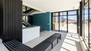 Un área de recepción moderna con una escalera, un mostrador de recepción y un banco.