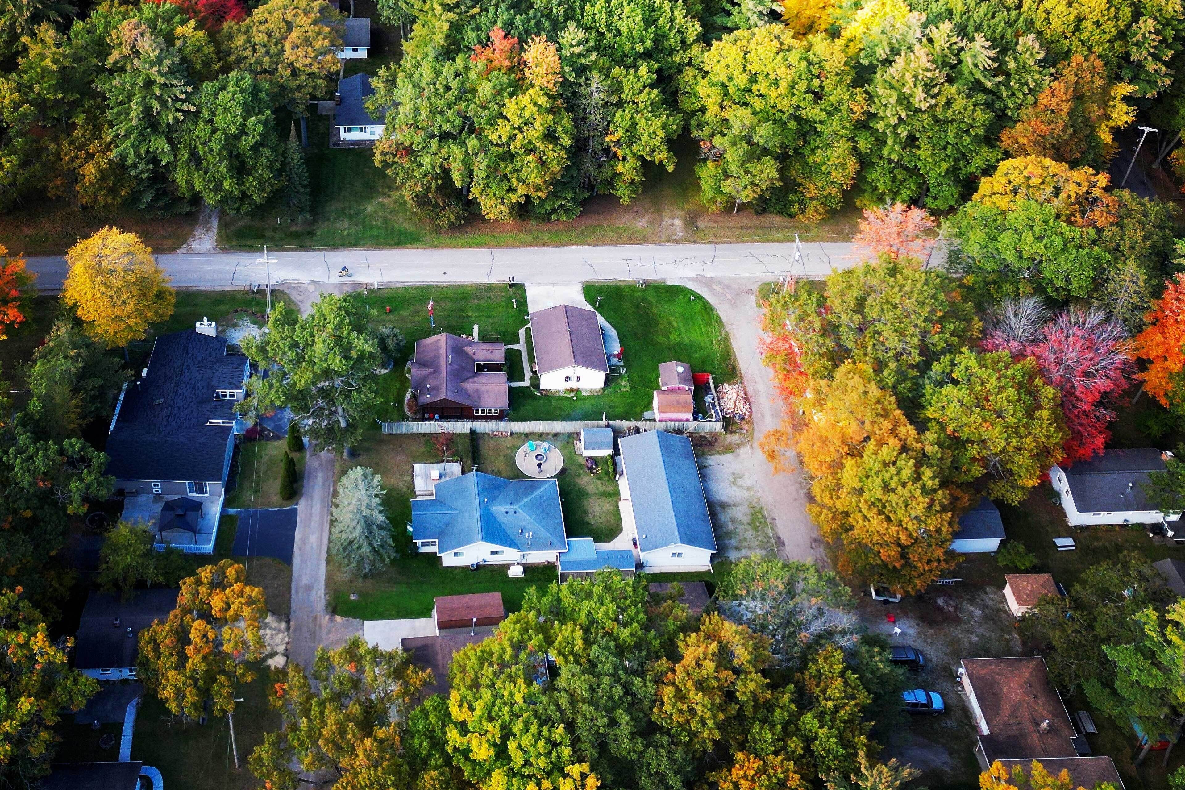 Vue aérienne d’un quartier résidentiel avec des maisons, des routes et les arbres environnants.