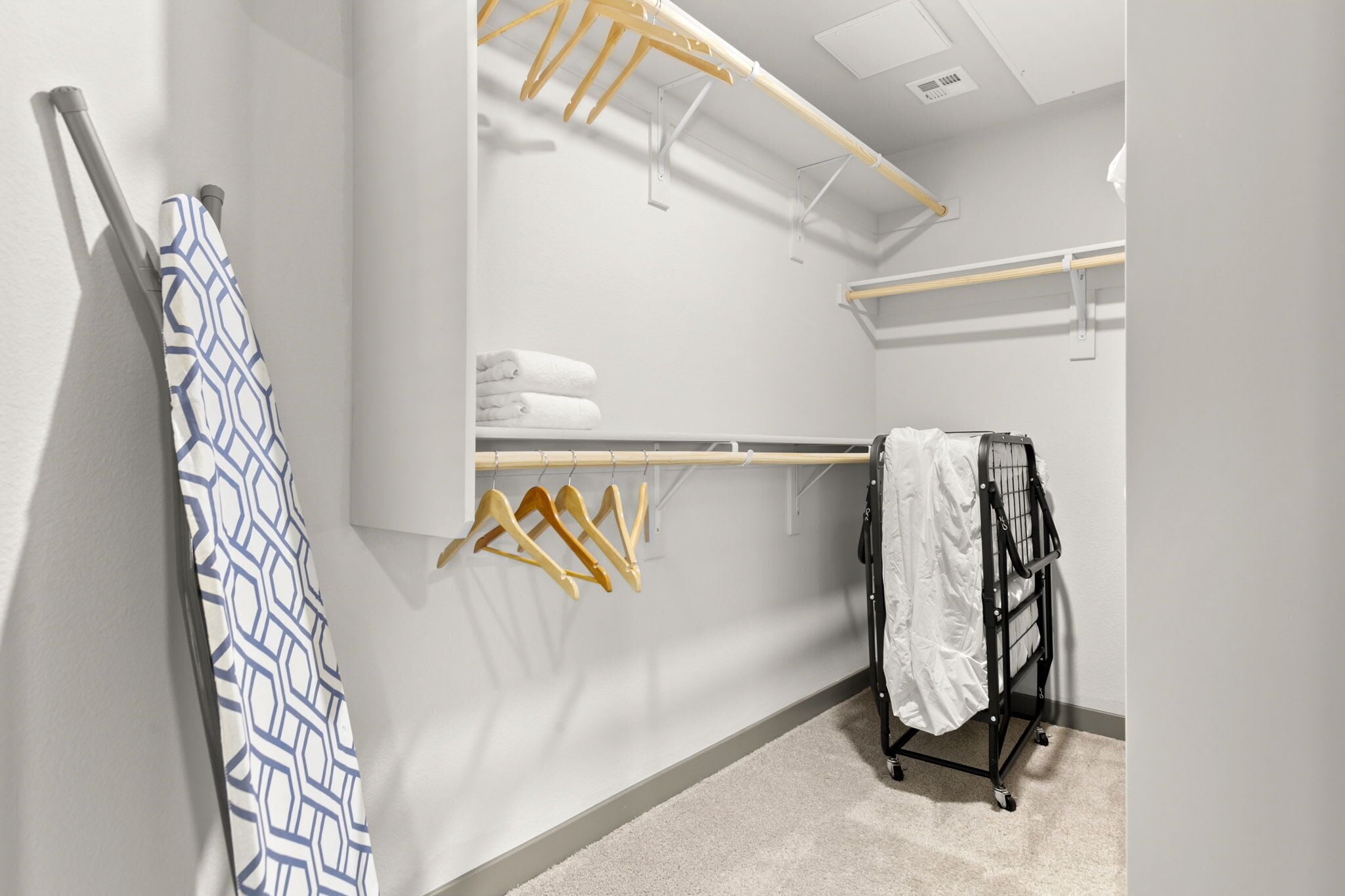 Une salle de bain d’hôtel équipée d’un porte-serviettes, d’un étendoir et d’un chariot.