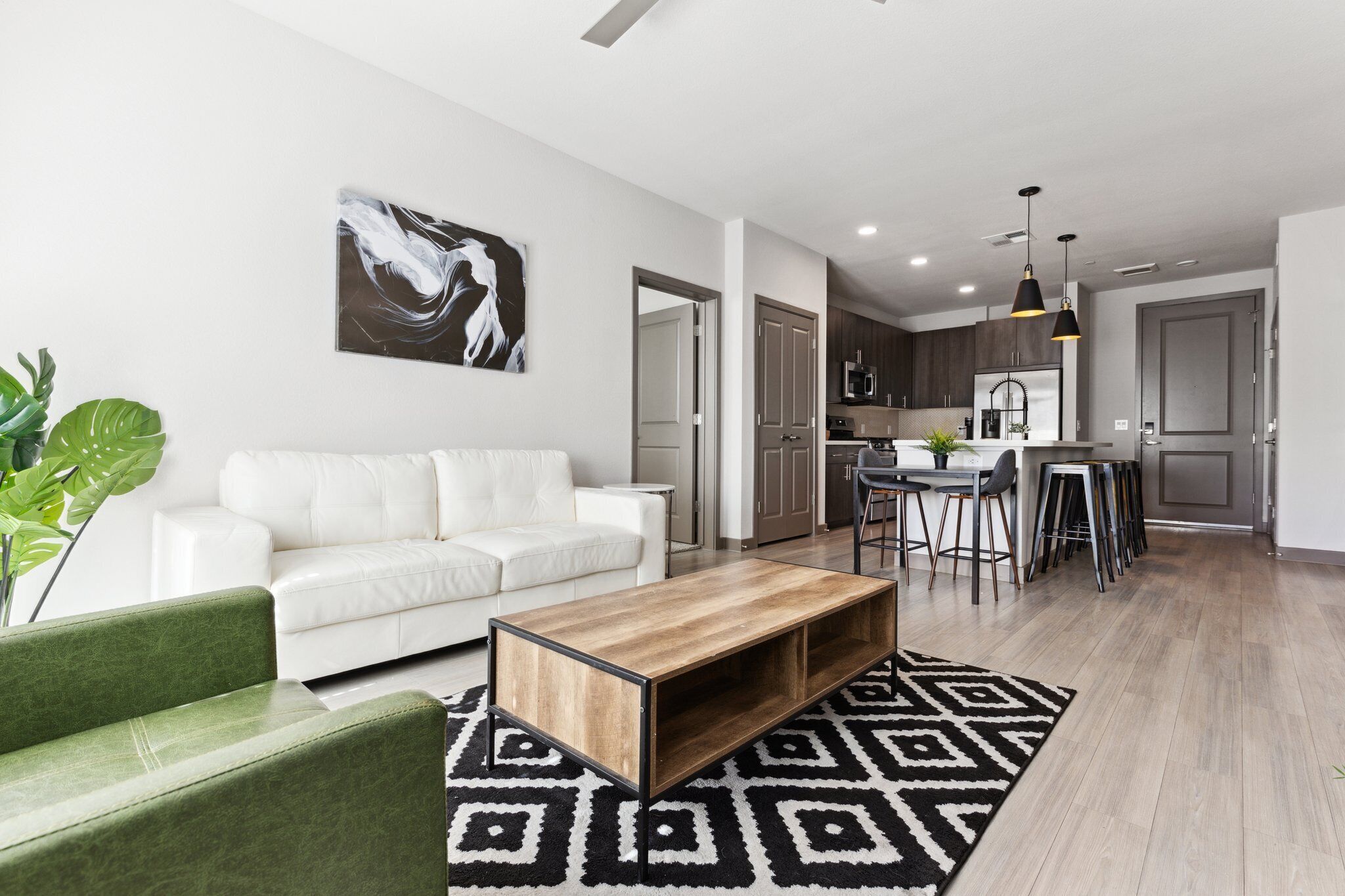 A modern living room with a white sofa, a wooden coffee table, and a patterned rug.