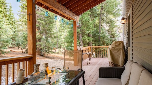 A covered outdoor patio with a glass-top table, wicker furniture, and a fire feature. - PET-FRIENDLY FOREST RETREAT CABIN | HOT TUB, FIRE-PIT, & A/C (Duck Creek Village)