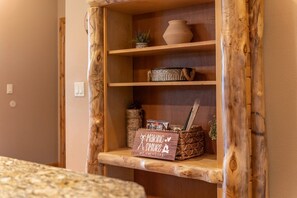 A wooden shelf unit with a sign that reads 'Making Memories.' - PET-FRIENDLY FOREST RETREAT CABIN | HOT TUB, FIRE-PIT, & A/C (Duck Creek Village)