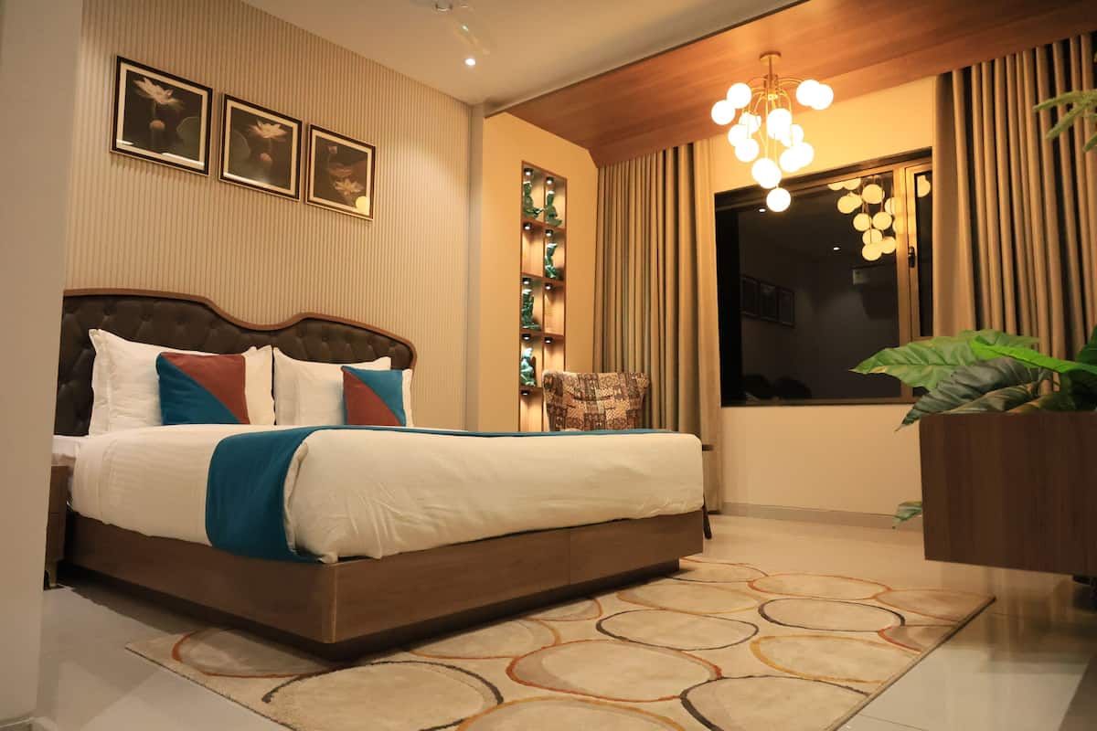 Une chambre moderne avec un grand lit, un mur décoratif, un lustre et une plante en pot.